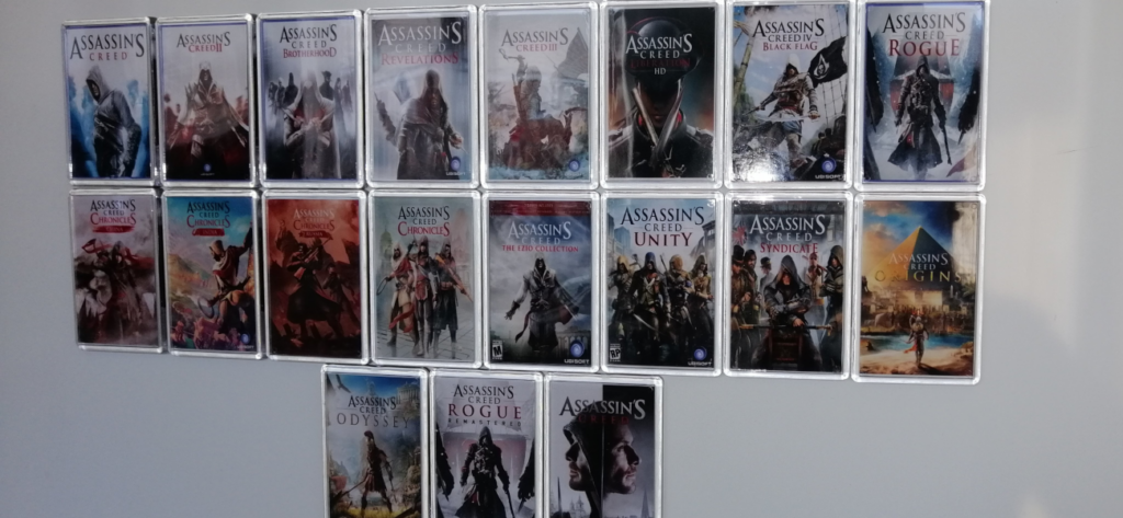 A set of 19 Assassin's Creed video game -inspired fridge magnets in place on a white fridge
