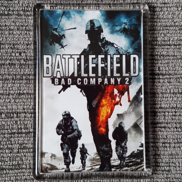 A circular image of a Battlefield Bad Company 2 video game fridge magnet on a carpet background