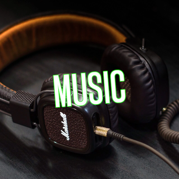 A set of stereo headphones on a dark table with the word Music