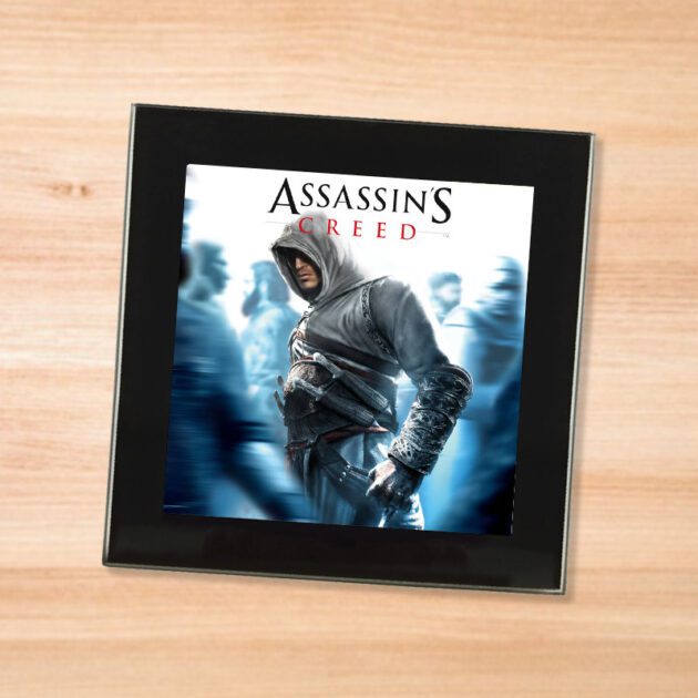 Black glass Assassin's Creed coaster on a wood table