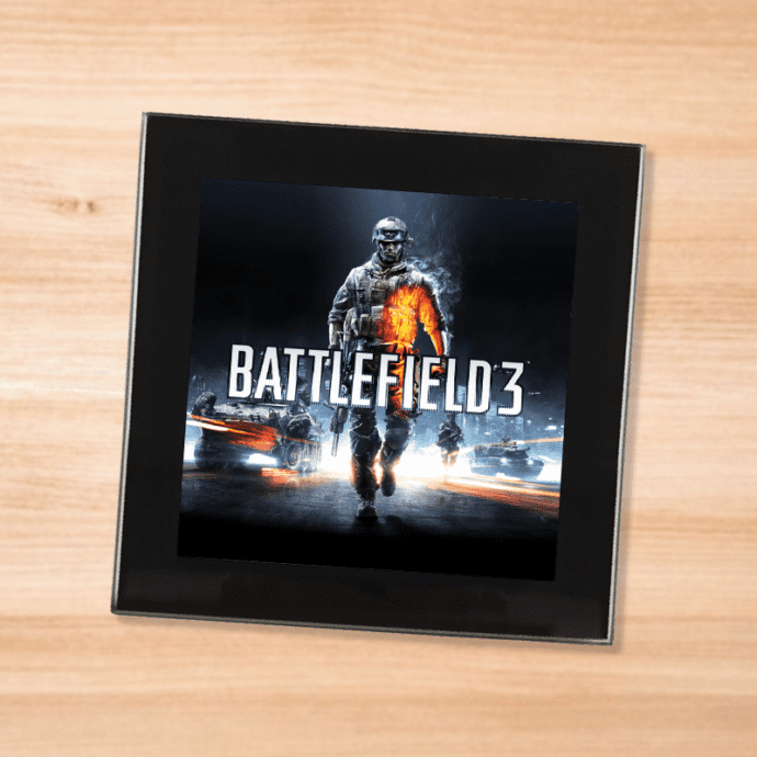 Black glass Battlefield 3 coaster on a wood table