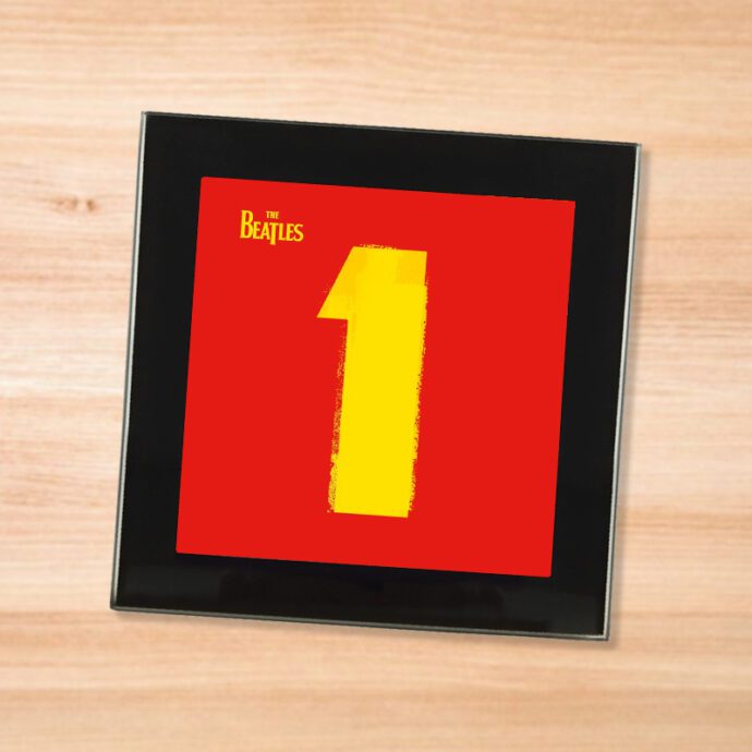 Black glass The Beatles - 1 coaster on a wood table