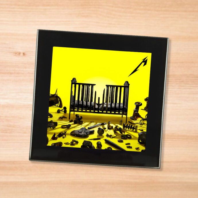 Black glass Metallica - 72 Seasons coaster on a wood table