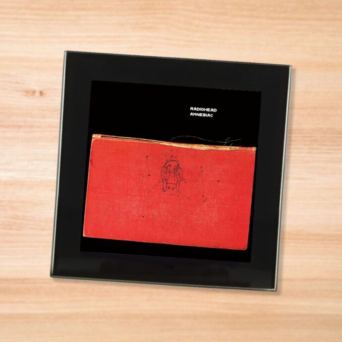 Black glass Radiohead - Amnesiac coaster on a wood table