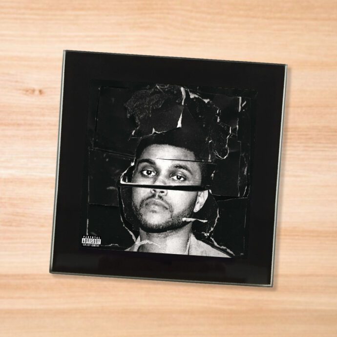 Black glass The Weeknd - Beauty Behind the Madness coaster on a wood table