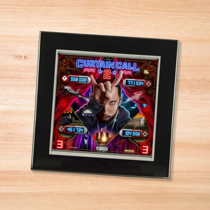 Black glass Eminem - Curtain Call 2 coaster on a wood table