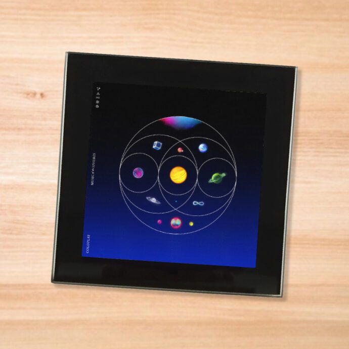 Black glass Coldplay - Music of the Spheres coaster on a wood table