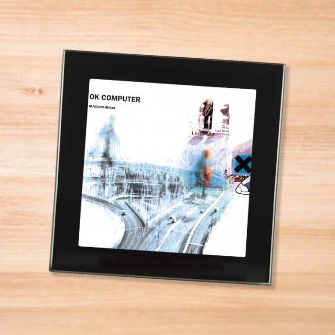 Black glass Radiohead - OK Computer coaster on a wood table