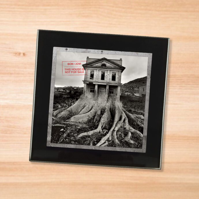 Black glass Bon Jovi - This House is Not For Sale coaster on a wood table