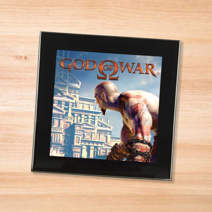 Black glass God of War coaster on a wood table