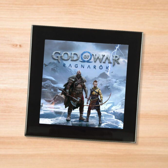 Black glass God of War Ragnarok coaster on a wood table