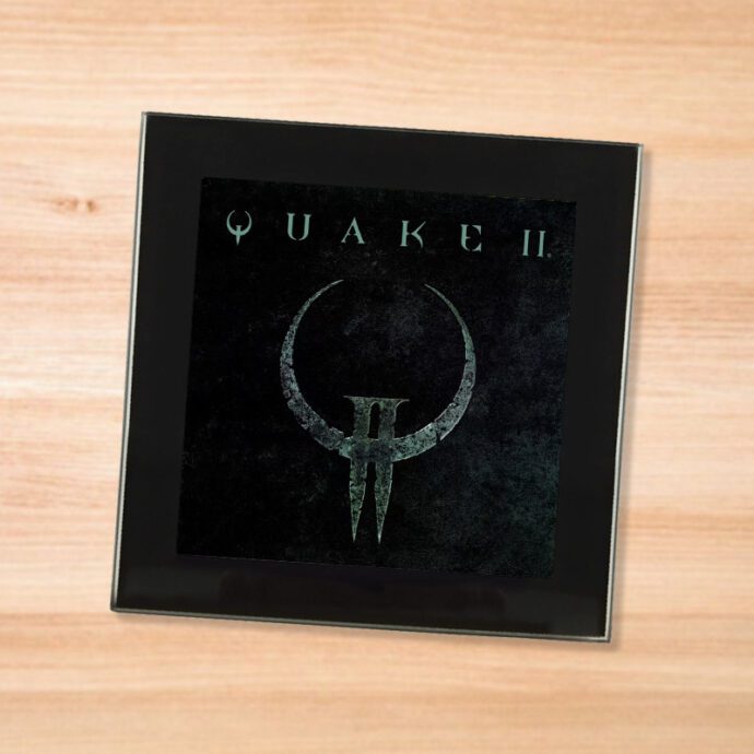 Black glass Quake 2 coaster on a wood table