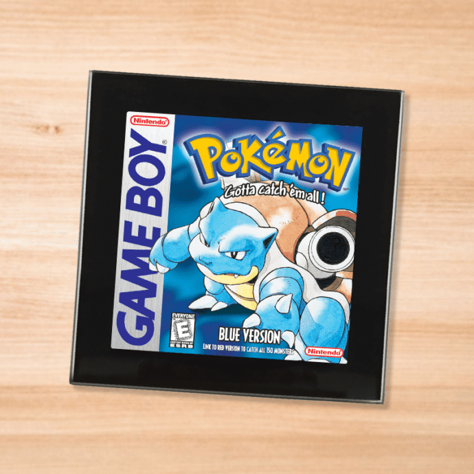 Pokemon Blue black glass coaster on a wood table