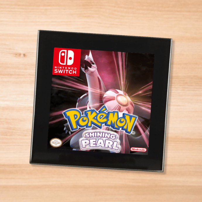 Pokemon Shining Pearl black glass coaster on a wood table