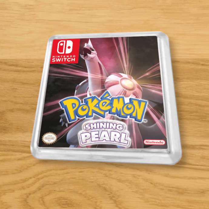 Pokemon Shining Pearl plastic coaster on a wood table