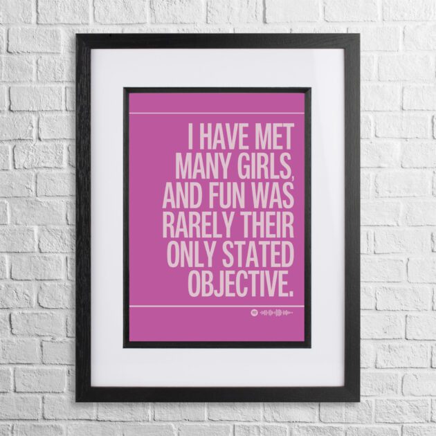 Girls Just Want To Have Fun by Cyndi Lauper funny lyrics print on a pink background in a black frame on a white brick wall